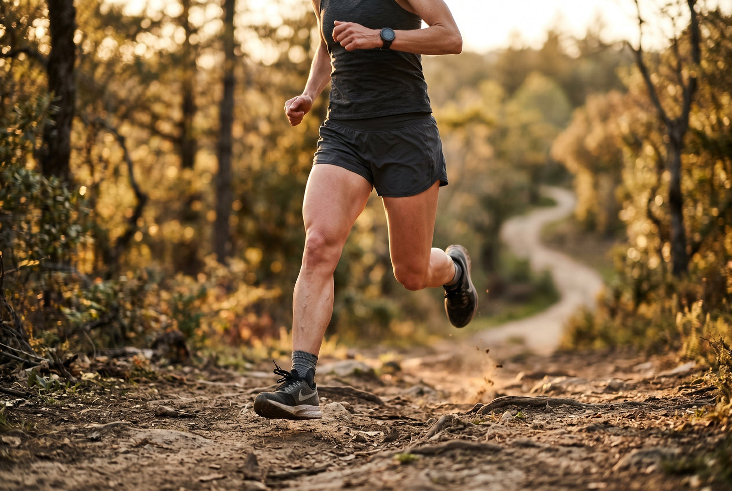 Trail runner mid-stride on a sunlit path at golden hour, highlighting legs and joint movement
