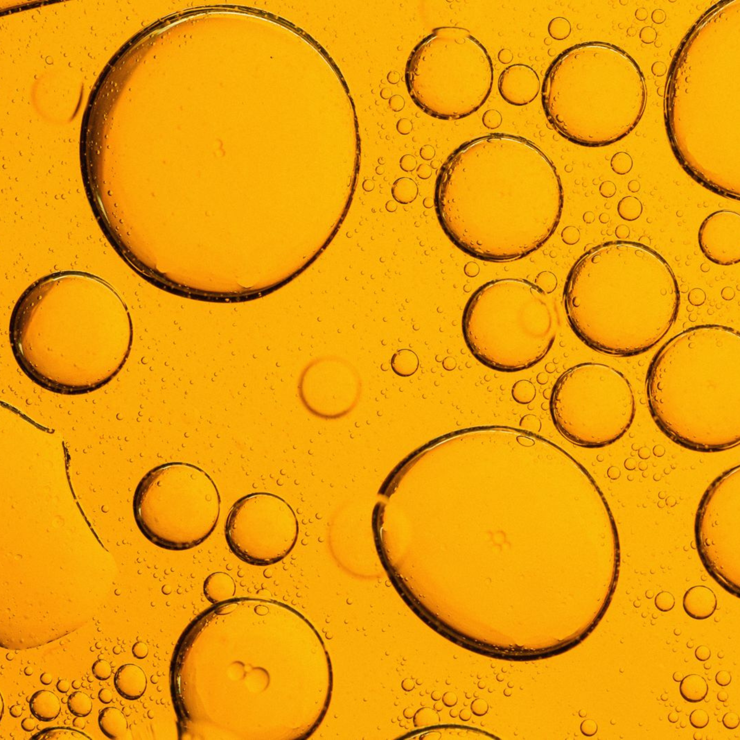Close-up of oil and water bubbles on a yellow background