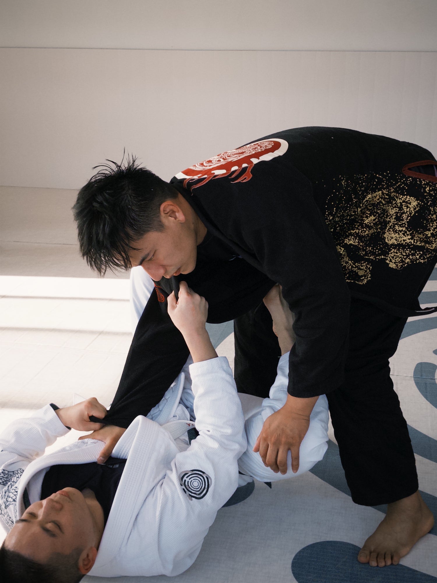 Jackson in Brazilian_Jiu-Jitsu uniform practicing a technique on a mat.